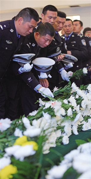 追悼会现场,交警支队的同志们为昔日战友潘超俊献上白菊.