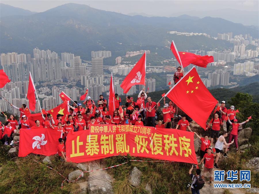 百余名香港市民爬上狮子山顶挥舞国旗、区旗
