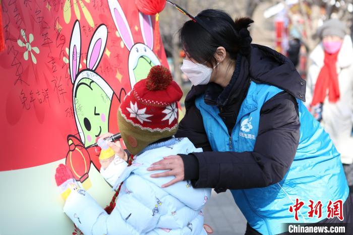 The picture shows little tourists writing New Year greetings in Beijing Zizhuyuan Park.Photo courtesy of Beijing Park Management Center