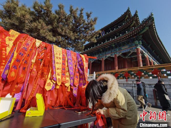 The picture shows tourists writing Chinese New Year messages in Jingshan Park in Beijing.Photo courtesy of Beijing Park Management Center