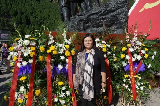 公祭仪式中,开国大将肖劲光孙女肖雨青在其敬献的花篮前留影.资料图