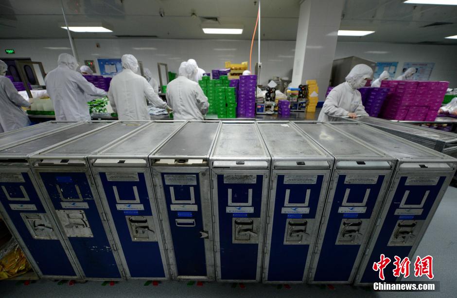 图为工作人员将打包好的餐盒放进餐车.王东明摄