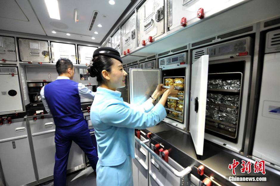 图为空乘在飞机上整理烤箱内的食物.王东明摄 本文转自:温州网