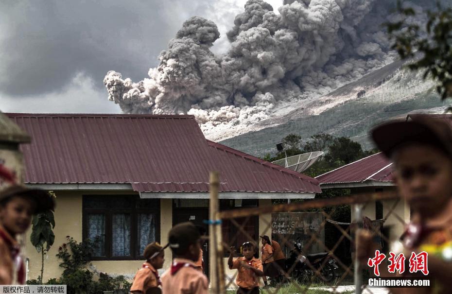 印尼锡纳朋火山喷发 学生不惧火山灰淡定玩耍