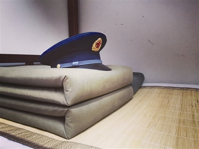 被,被叠得像豆腐块一样,方方正正地摆放在床上,被子上面放着一顶军帽