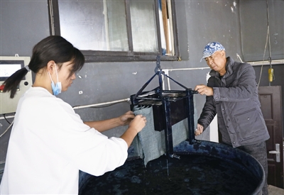 王河生和学徒在制作蓝夹缬制品